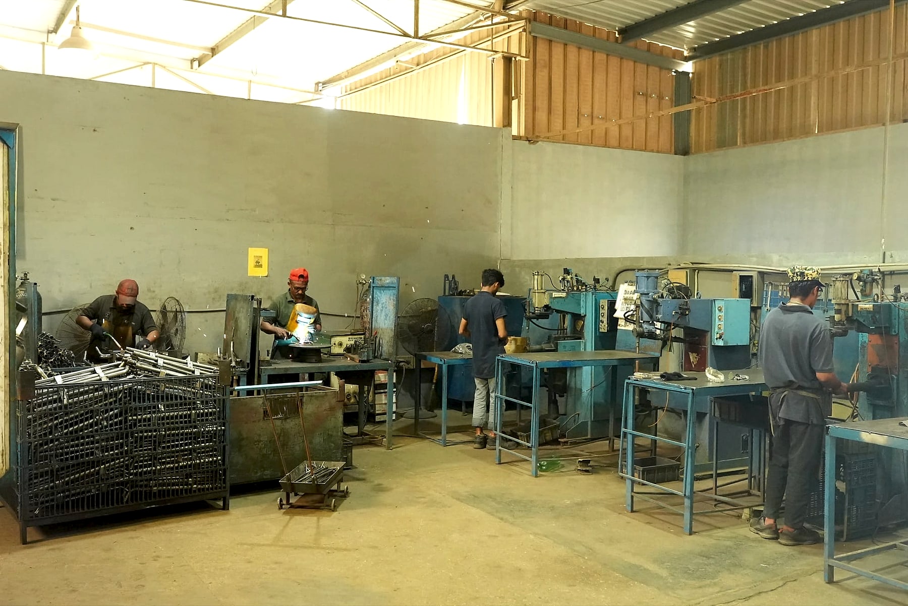 Welding shop with MIG welding benches and a row of pedestal spot welding machines