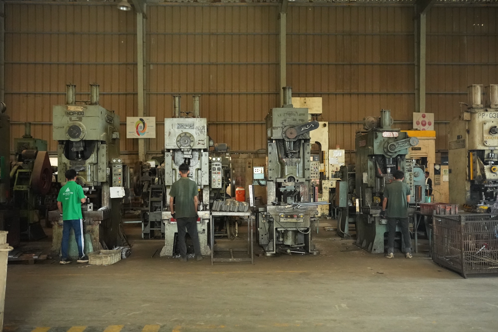 Operators working at a row of mechanical presses of different tonnages