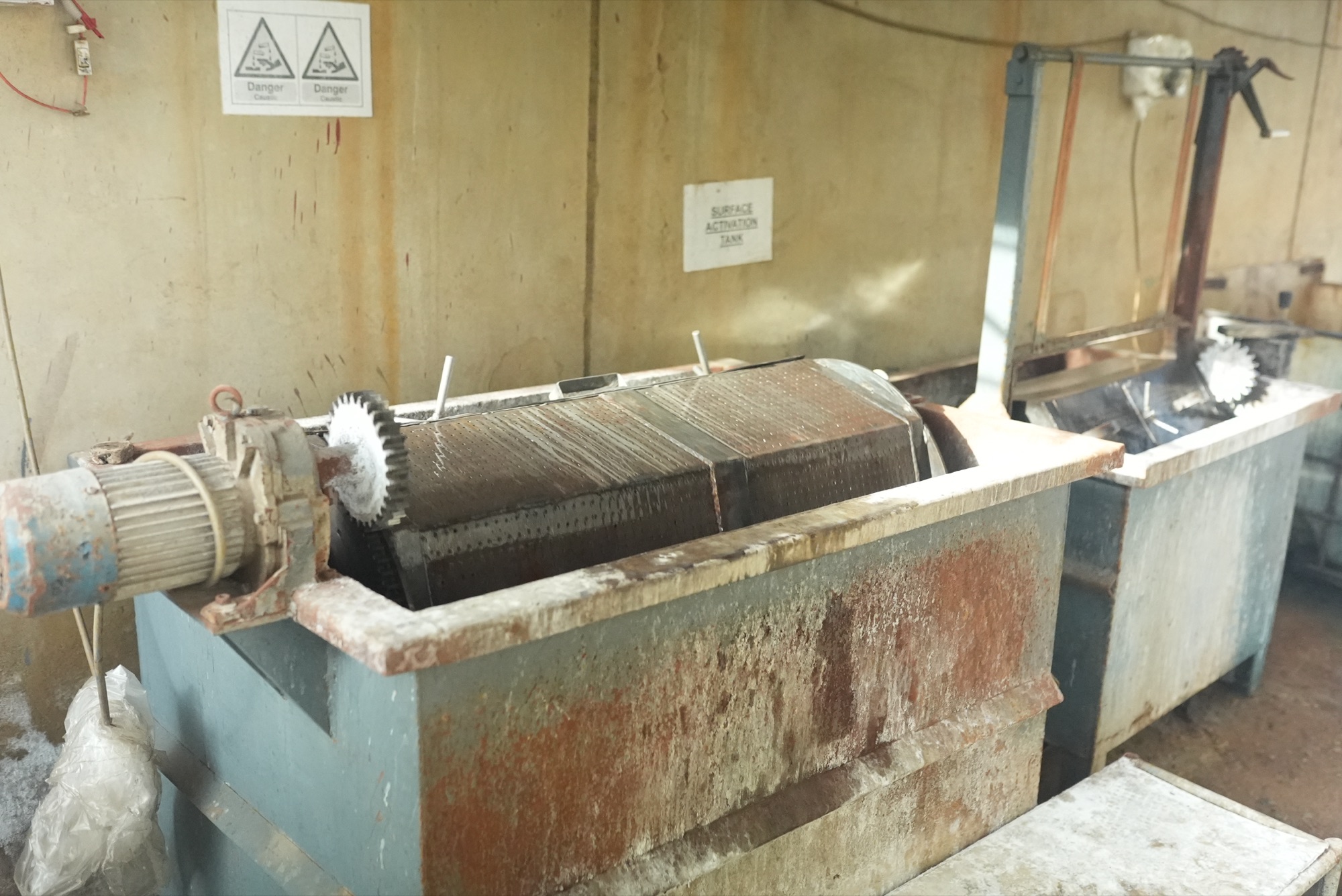 Motor-driven perforated barrel sitting in a surface activation tank