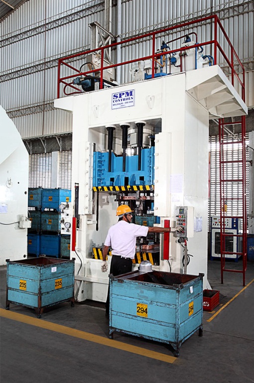 SAPL press shop operator running an SPM Controls hydraulic stamping press on the production floor