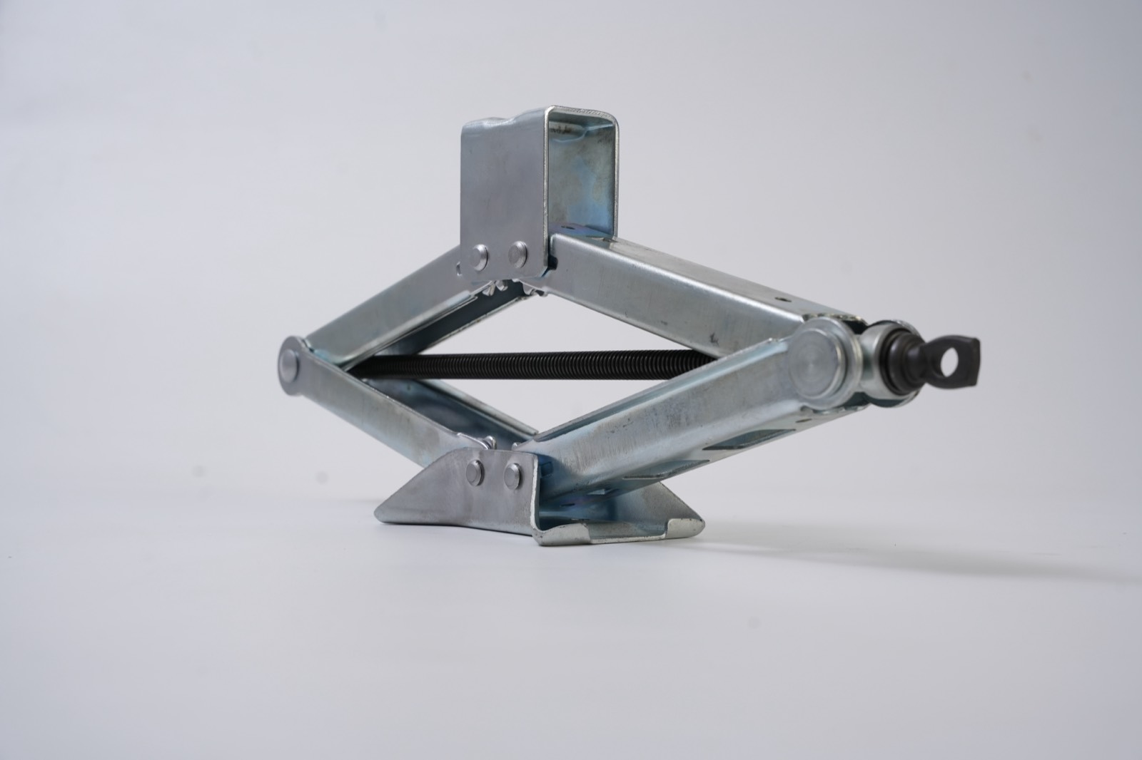 Zinc-plated scissor jack with eye drive end from an angled view