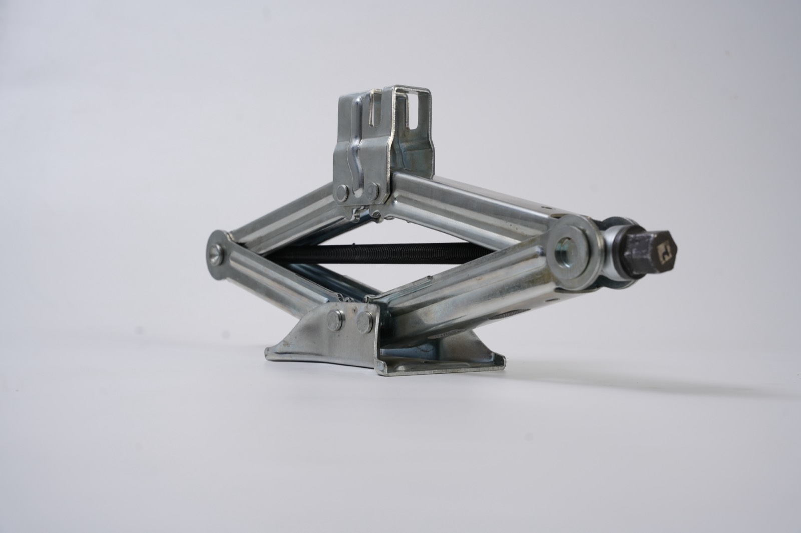 Zinc-plated scissor jack with hex drive end from an angled view