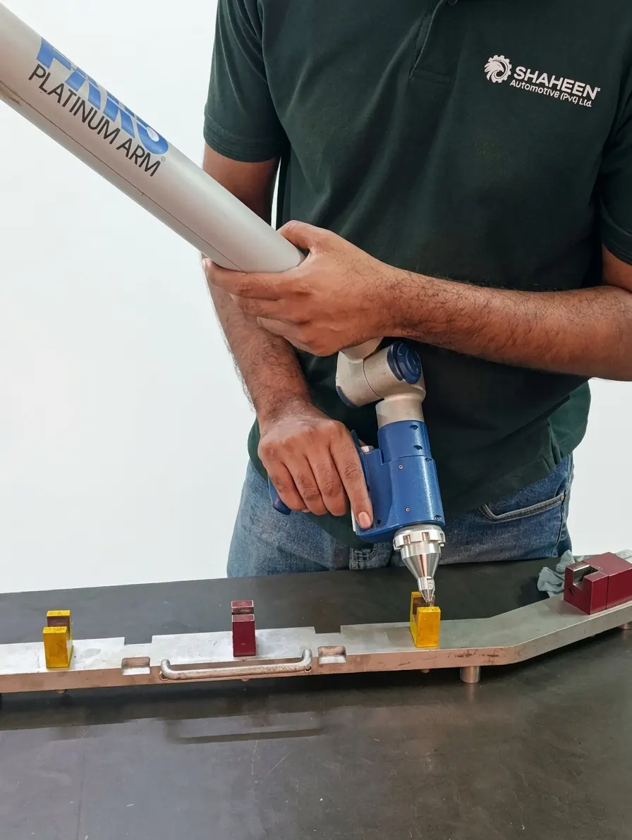 Inspector in a Shaheen Automotive shirt measuring a checking fixture with a FARO Platinum Arm probe